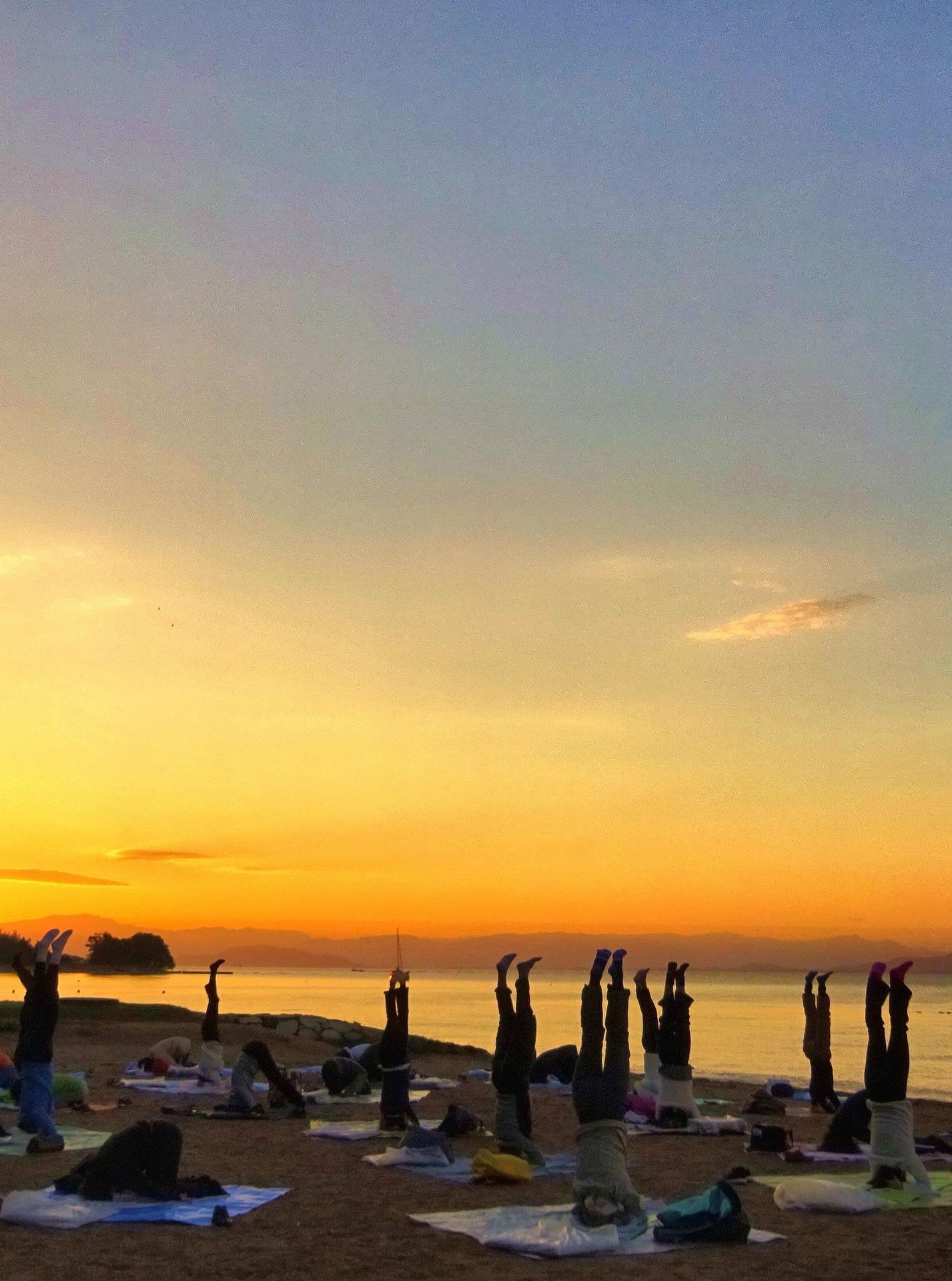 シルシ・アーサナ(頭立ち)の   　ポーズで日の出を迎える